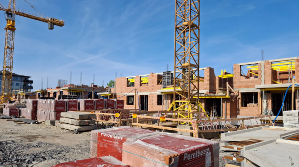 Realizacja stanu surowego otwartego od zera - murowanie ścian budynku wielorodzinnego i praca żurawia wieżowego.